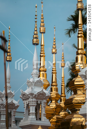 Ornate white temple spire with golden pagoda in Thailand, Traditional Buddhist architecture detail with intricate carving and sacred design Ornate white temple spire with golden pagoda in Thailand, Traditional Buddhist architecture detail with intricate carving and sacred design 141914158