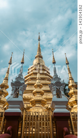 Golden Buddhist temple with ornate pagoda and spires in Chiang Mai, Traditional Thai shrine architecture with gilded stupa and cultural landmark Golden Buddhist temple with ornate pagoda and spires in Chiang Mai, Traditional Thai shrine architecture with gilded stupa and cultural landmark 141914162