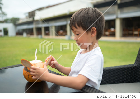 Multiracial boy enjoys fresh coconut drink outdoors in Sri Lanka Multiracial boy enjoys fresh coconut drink outdoors in Sri Lanka 141914450