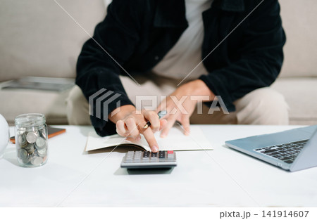 Close up of businesswoman or accountant hand typing laptop working to calculate on desk about cost at home office. Close up of businesswoman or accountant hand typing laptop working to calculate on desk about cost at home office. 141914607