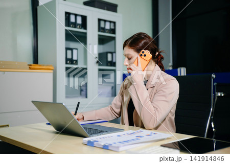 Confident business expert attractive smiling young woman holding digital tablet  on desk in creative office. 141914846