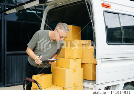 Professional courier holding parcel beside delivery van. Logistics, shipping, ecommerce, warehouse, last mile delivery, express service and reliable package transportation. Professional courier holding parcel beside delivery van. Logistics, shipping, ecommerce, warehouse, last mile delivery, express service and reliable package transportation. 141914931
