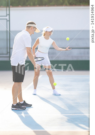 Coach teaching woman how to play tennis Coach teaching woman how to play tennis 141914964
