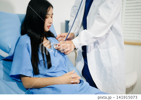 Patient reviewing and signing medical consent documents with healthcare staff during hospital registration, consultation, treatment preparation and care. 141915073