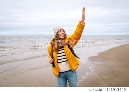 Attractive woman on a windy cold beach. Travel, nature concept. Attractive woman on a windy cold beach. Travel, nature concept. 141915449