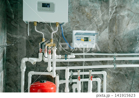 a functional and clean water heater system installed and operational in an indoor residential or commercial setting, viewed from a side perspective at a slight elevation, featuring visible. a functional and clean water heater system installed and operational in an indoor residential or commercial setting, viewed from a side perspective at a slight elevation, featuring visible. 141915623