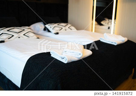 Modern hotel room bedroom interior with made beds and fresh towels Modern hotel room bedroom interior with made beds and fresh towels 141915872