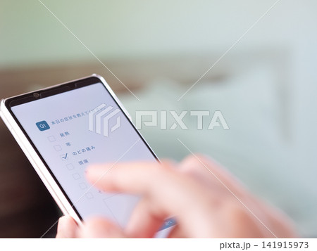 スマホでオンライン問診票を入力手元写真。(画面はオリジナル制作のイメージ画像) 141915973