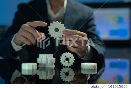 Close up of Asian businessman hand holding gear cog for system optimization concept. 141915992