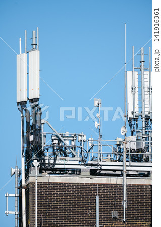 Corby, Northamptonshire, UK - August 2, 2026: Telecommunications antennas on rooftop of office building in Corby, England Corby, Northamptonshire, UK - August 2, 2026: Telecommunications antennas on rooftop of office building in Corby, England 141916361
