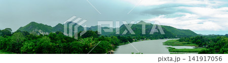 Tranquil mountain river flowing gently through lush green forest River Kwai Panoramic Landscape in Kanchanaburi, Thailand 141917056