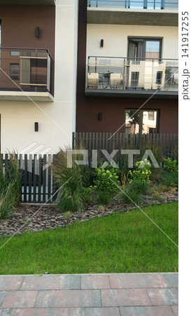 Modern residential building facade featuring contemporary architecture, elegant balconies, green lawn, garden landscaping Modern residential building facade featuring contemporary architecture, elegant balconies, green lawn, garden landscaping 141917255