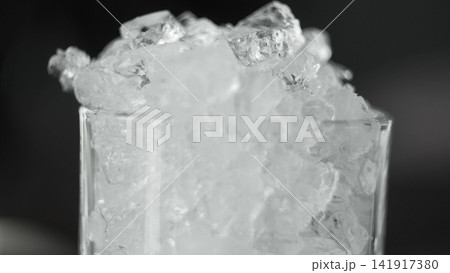 Crushed ice filling a clear glass, creating a refreshing frozen texture and cold beverage concept 141917380