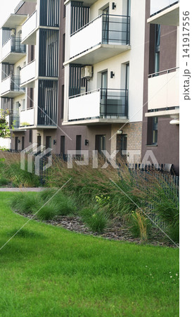 Contemporary apartment building facade showing sustainable urban landscape design with green lawn Contemporary apartment building facade showing sustainable urban landscape design with green lawn 141917556