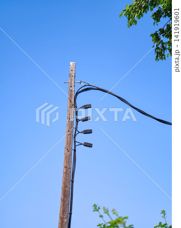 Wooden utility pole connecting electric power lines under blue sky 141919601