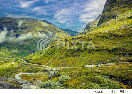 Autumn mountain landscape in Norway. Winding road in the mountains. Road 63 to Geiranger. View from Upper Blaafjeld Bridge Autumn mountain landscape in Norway. Winding road in the mountains. Road 63 to Geiranger. View from Upper Blaafjeld Bridge 141919951