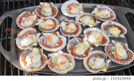 Fresh scallops grilled on cast iron skillet over barbecue 141920948