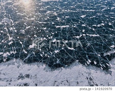 細かな氷紋と雪が浮かぶバイカル湖の冬をドローン撮影 141920970