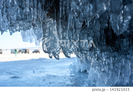 凍結バイカル湖を背景に連なる岩場の青い氷柱 141921015