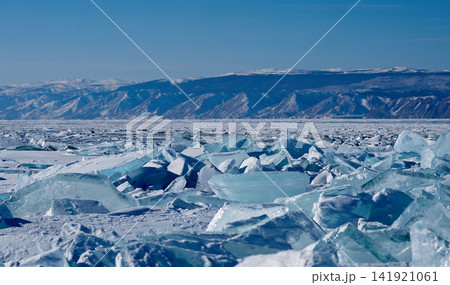 氷のかけら越しに広がる冬のバイカル湖と雪山 141921061