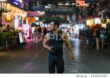 Male photographer exploring vibrant khao san road at night 141924360