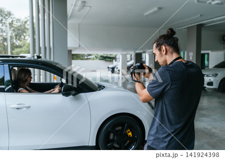 Photographer capturing images of woman in car Photographer capturing images of woman in car 141924398