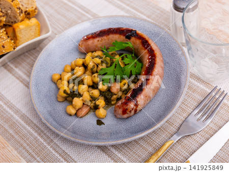 Sausage served with chickpeas and spinach Sausage served with chickpeas and spinach 141925849