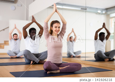 People exercising lotus asana in gym People exercising lotus asana in gym 141926218