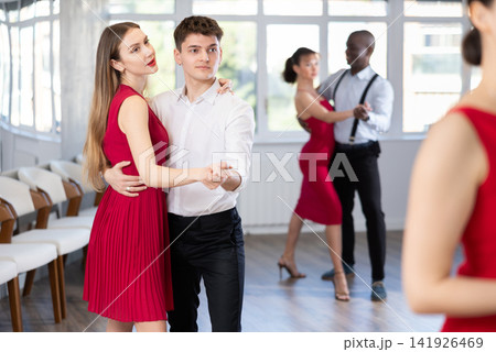 Young man and girl dancing waltz in couple during lesson at studio Young man and girl dancing waltz in couple during lesson at studio 141926469