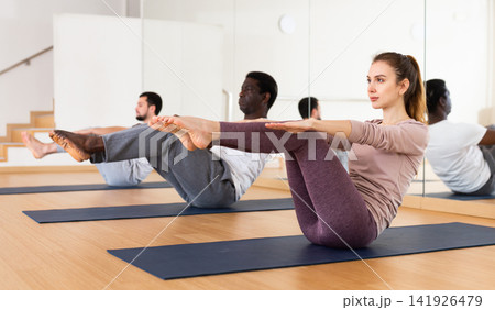 Young woman doing static exercise during group fitness training Young woman doing static exercise during group fitness training 141926479