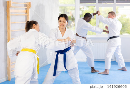 Block, then strike. Shot of two female martial artists practicing karate in gym 141926606