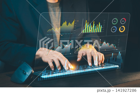 Businessman typing on computer keyboard with interactive financial analytics dashboard interface, stock market research and big data visualization. Businessman typing on computer keyboard with interactive financial analytics dashboard interface, stock market research and big data visualization. 141927286