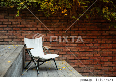 Empty chair awaits someone to relax in tranquil outdoor space Empty chair awaits someone to relax in tranquil outdoor space 141927524