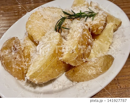 粉チーズとローズマリーを添えた黄金色のポテトウェッジ 141927787