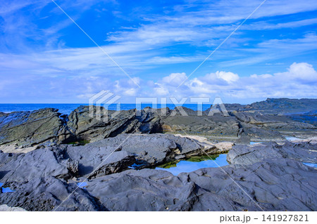 夏の晴天の朝 城ヶ島の複雑な形状の岩場と向こうに見え隠れする水平線と青空の風景 夏の晴天の朝 城ヶ島の複雑な形状の岩場と向こうに見え隠れする水平線と青空の風景 141927821