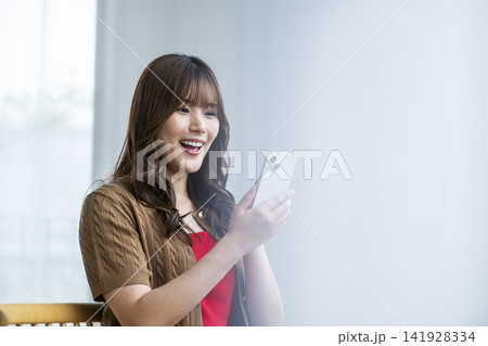 若い女性　スマホ　笑顔　検索 141928334