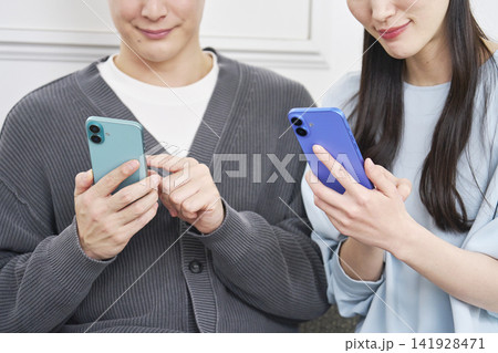 リビングでスマホを使っているカップル　顔無し 141928471