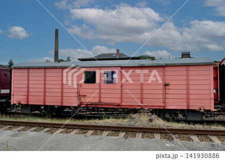 Vintage red cargo boxcar standing on old railway tracks Vintage red cargo boxcar standing on old railway tracks 141930886