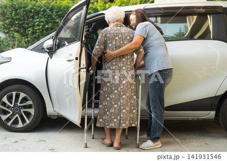 Caregiver help Asian elderly woman disability patient get into car. Caregiver help Asian elderly woman disability patient get into car. 141931546
