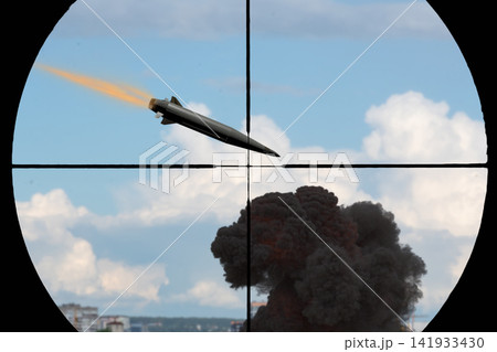 Missile flying through sniper scope crosshairs above dark explosion and clouds Missile flying through sniper scope crosshairs above dark explosion and clouds 141933430