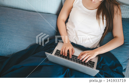 Young adult asian woman using laptop on bed, lifestyle routine working online rest in cozy bedroom Young adult asian woman using laptop on bed, lifestyle routine working online rest in cozy bedroom 141933719