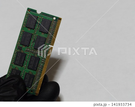 ノートパソコン(PC)のメインメモリ(RAM)1枚を手に持つ ノートパソコン(PC)のメインメモリ(RAM)1枚を手に持つ 141933734