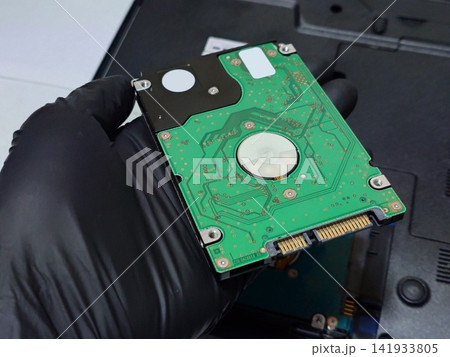 2.5インチHDD（ハードディスク）を手に持つ 141933805