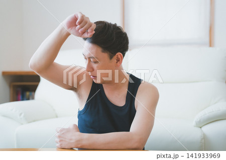 リビングで脇の体臭を確認する40代男性のメンズデオドラント リビングで脇の体臭を確認する40代男性のメンズデオドラント 141933969