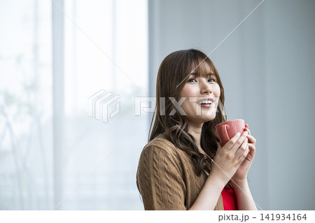 窓際でコーヒーを飲む若い女性 窓際でコーヒーを飲む若い女性 141934164