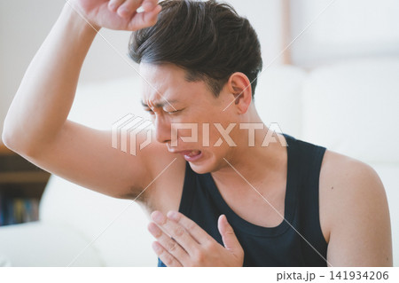 手で風を送り脇の臭いを嗅ぐ40代男性のメンズにおいチェック 141934206