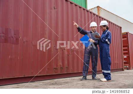 Male and female workers discussing logistics at shipping container yard Male and female workers discussing logistics at shipping container yard 141936852
