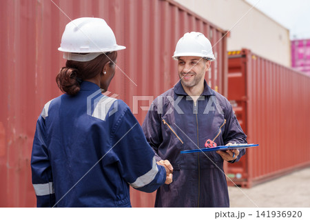 Female engineer shaking hands with male colleague on construction site Female engineer shaking hands with male colleague on construction site 141936920