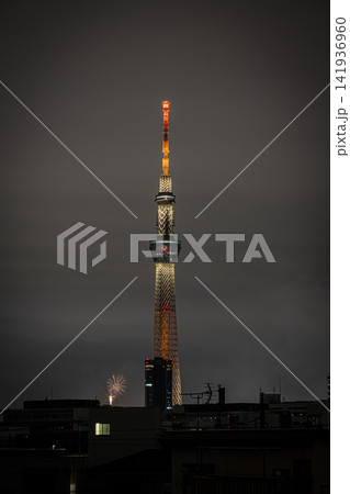 東京スカイツリーと隅田川花火大会の美しい大輪の花火が彩る夏の夜景 141936960