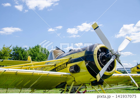 Samples of old military equipment. The engine and propeller of the cargo plane against blue cloudy sky. Separate parts of the fuselage, close-up. Old airplane in museum of aviation at Retro cars 141937075